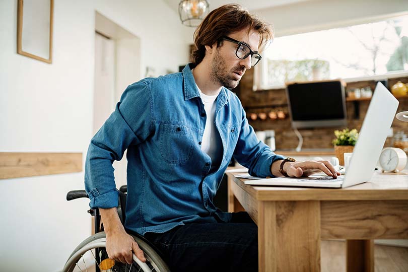 Man in wheelchair working on a laptop